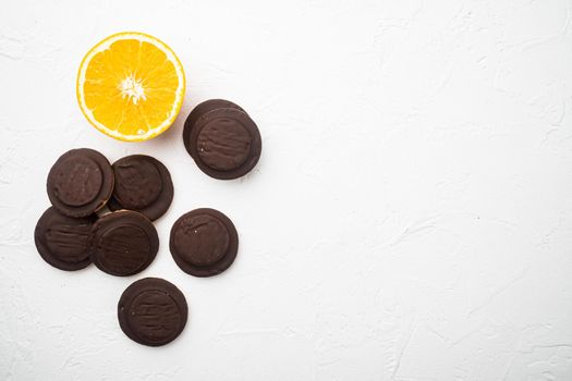 Jaffa Cakes. Cookies covered with dark chocolate and filled with orange marmalade set, on white stone table background, top view flat lay, with copy space for text
