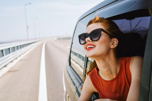 woman looking out of car window wearing sunglasses travel lifestyle. High quality photo