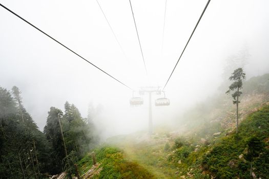 Chairlift in ski resort on foggy day during off-season in Sochi
