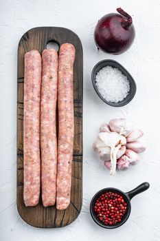 Homemade beef sausages, top view, on white background.