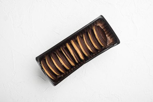 Polish chocolate chip cookies for dessert set, in plastic tray container, on white stone table background, top view flat lay, with copy space for text