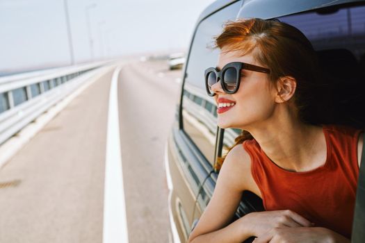 woman looking out of car window wearing sunglasses travel lifestyle. High quality photo