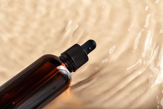 Cosmetic bottle with pipette in wavy water, top view