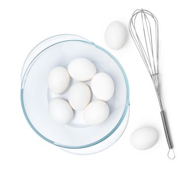 Fresh eggs with whisk isolated on white background, close up