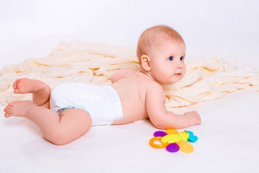 Cute baby girl on white background. Baby in diaper with toy