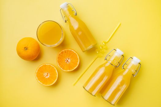 Fresh orange juice set, on yellow textured summer background, top view flat lay