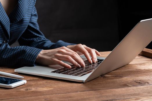 Business lady typing on laptop computer at wooden desk. Strategy planning and banking. Financial analyst working in office. Business accounting and project management. Close up woman hands on keyboard