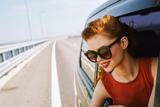 woman looking out of car window wearing sunglasses travel lifestyle. High quality photo