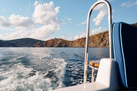 Motor yacht cruising in the open sea, view from the stern