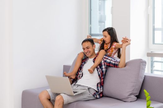 Father and daughter laughing on laptop