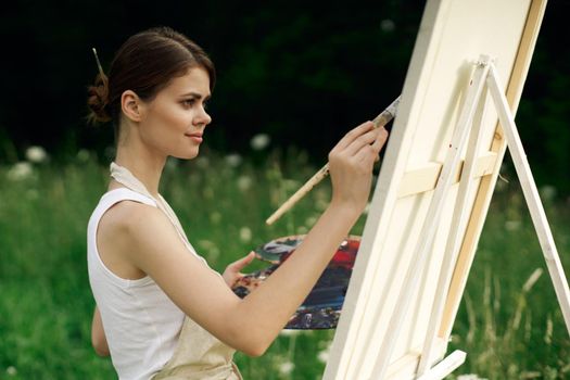 cheerful woman artist painting a picture outdoors creative art. High quality photo