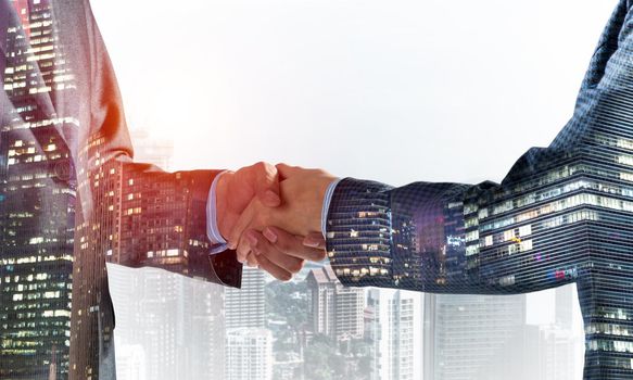 Close-up of the handshake of businessmen. Against the backdrop of the cityscape