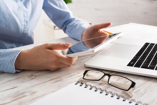 Business lady sitting at desk with tablet computer. Corporate office workplace with laptop. Mobile smart device in business processes. Business occupation concept with business woman at wooden desk.
