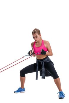 Strong woman using a resistance band in her exercise routine. Young woman performs fitness exercises on white background. Woman with beautiful slim healthy body posing in studio.