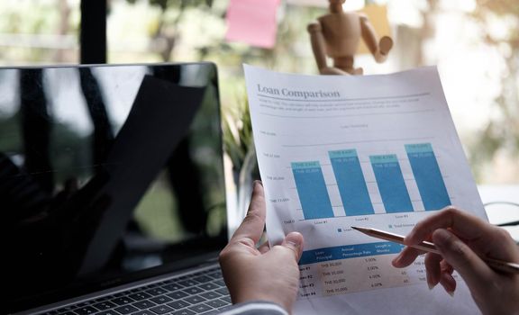 Business women reviewing data in financial charts and graphs.