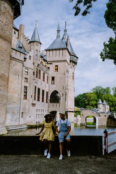 Castle de Haar Utrecht, couple men and woman mid age European and Asian visit De Haar Castle in Dutch Kasteel de Haar is located in Utrecht Netherlands during Spring with flowers in the garden