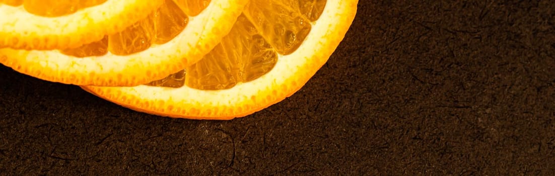 Part of orange slices on a dark background. Place for your text