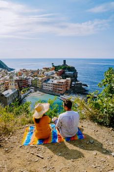 Cinque Terre, Italy, The picturesque coastal village of Vernazza, Cinque Terre, Italy, couple man, and woman European men and Asian woman watching the sunset at Vernazza Cinque Terre Italy