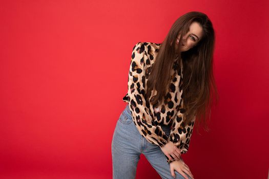 Close-up portrait of young nice-looking attractive lovely glamorous brunet woman wearing leopard blouse isolated on red color background with free space.