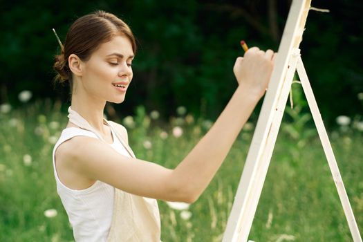 woman artist paints a picture on nature art hobby. High quality photo