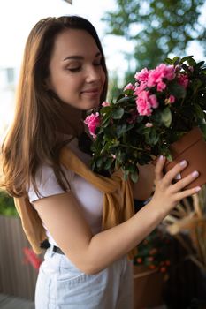 attractive young woman in casual look buys flowers in the store.