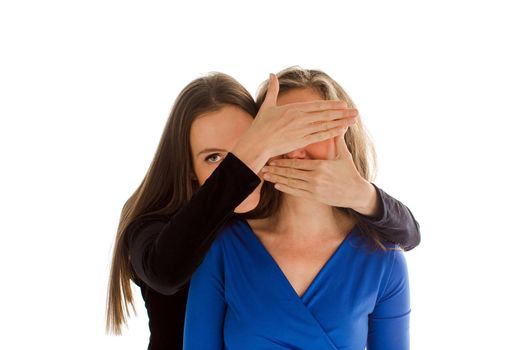Young woman in black jacket covering eyes and mouth of faceless female in blue jacket isolated on white background
