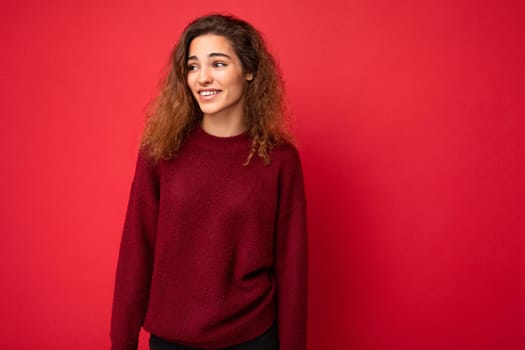 Shot of attractive happy smiling young woman wearing casual outfit standing isolated over colourful background with empty space looking to the side.