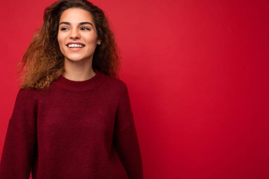 Shot of attractive happy smiling young woman wearing casual outfit standing isolated over colourful background with empty space looking to the side.