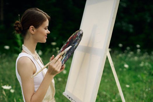 woman outdoors paint a picture landscape hobby creative. High quality photo