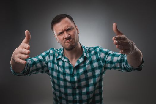 Portrait of excited man looking at the camera and points at you with a finger. Isolated on gray background. Emotion concept