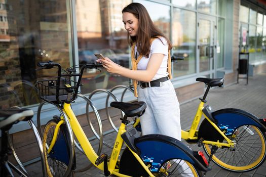 Caucasian young woman pays for bike rental in app.