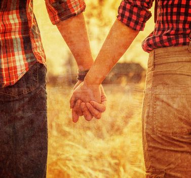 Young couple in love holding hands, tranquil scene, face is not visible. Vintage image