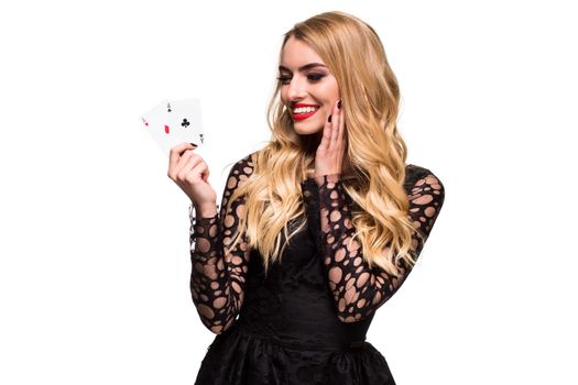 Beautiful blonde in a black dress with casino cards two aces in hands isolated on a white background. Poker. Casino. Roulette Blackjack Spin. Caucasian young woman looking at the camera. Winning combination