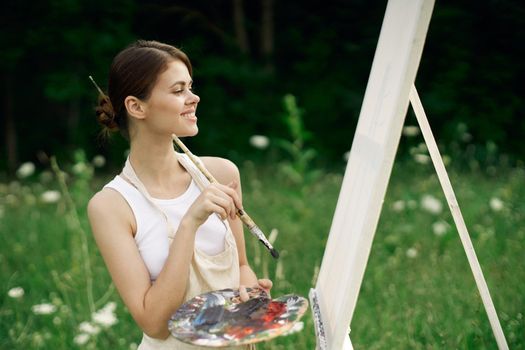 woman outdoors paint a picture landscape hobby creative. High quality photo