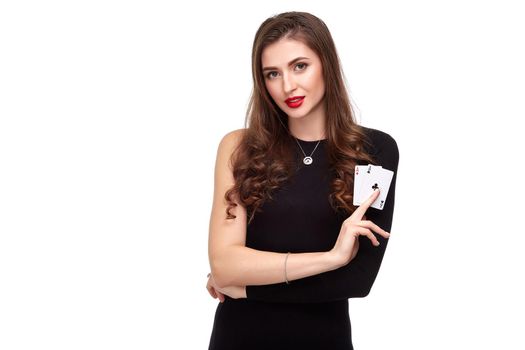 Sexy curly hair brunette in black dress posing with two aces cards in her hands, poker concept isolation on white background. winning combination