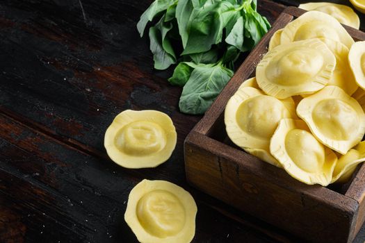 Homemade Ravioli with basil and tomatoes set, in wooden box, on old dark wooden table background, with copy space for text