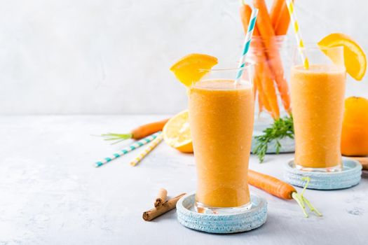Healthy breakfast with carrot smoothie with orange and cinnamon in glass jar and ingredients. Detox, diet, healthy, vegetarian food concept with copy space.