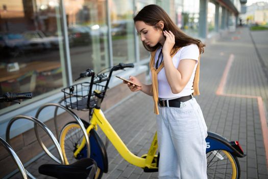 Caucasian young woman pays for bike rental in app.