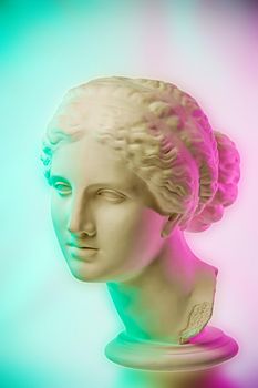 Statue of Venus de Milo. Creative concept colorful neon image with ancient greek sculpture Venus or Aphrodite head. Pink and green duotone effects. Webpunk, vaporwave and surreal art style.