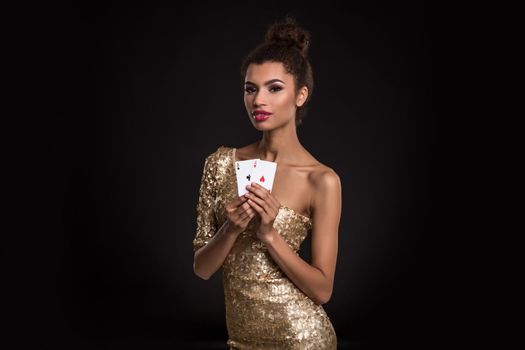 Pretty african girl shows two aces in casino poker and win Young woman in studio on black background