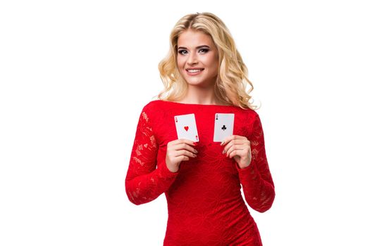 Caucasian young woman with long light blonde hair in evening outfit holding playing cards. Isolated on white background. Poker