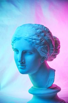 Statue of Venus de Milo. Creative concept colorful neon image with ancient greek sculpture Venus or Aphrodite head. Pink and blue duotone effects. Webpunk, vaporwave and surreal art style.