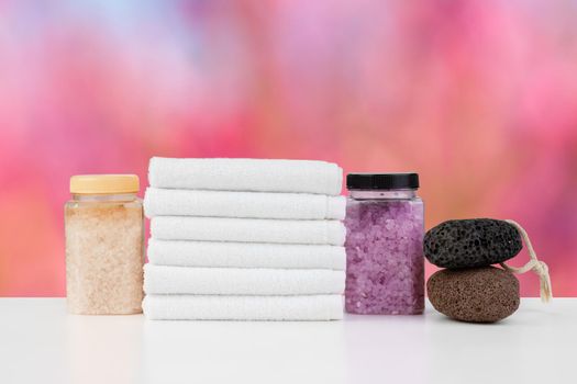 Various spa beauty threatment products and towels against blurred background, front view