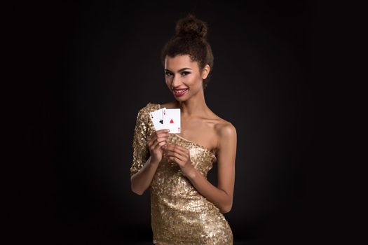 Pretty african girl shows two aces in casino poker and win Young woman in studio on black background