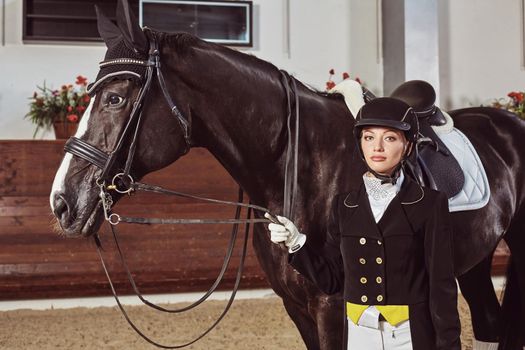 woman jockey with his horse in uniform for Dressage