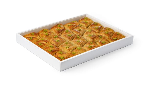Assortment of Turkish baklava dessert in a white box isolated on white background