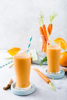 Healthy breakfast with carrot smoothie with orange and cinnamon in glass jar and ingredients. Detox, diet, healthy, vegetarian food concept with copy space.