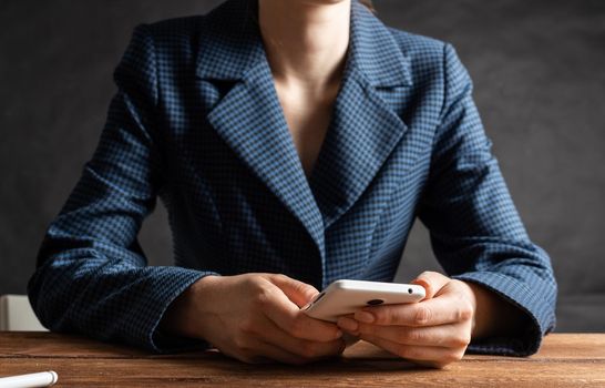 Businesswoman using mobile phone at desk. Close up woman hands and tablet computer. Mobile communication concept with chatting woman. Digital technology in strategy planning and company management