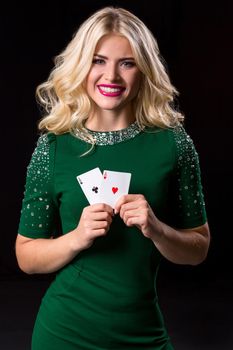 blonde woman in posing with cards for gambling on black background