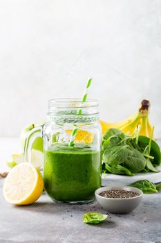 Healthy breakfast with green smoothie in glass jar and ingredients. Detox, diet, healthy, vegetarian food concept with copy space.